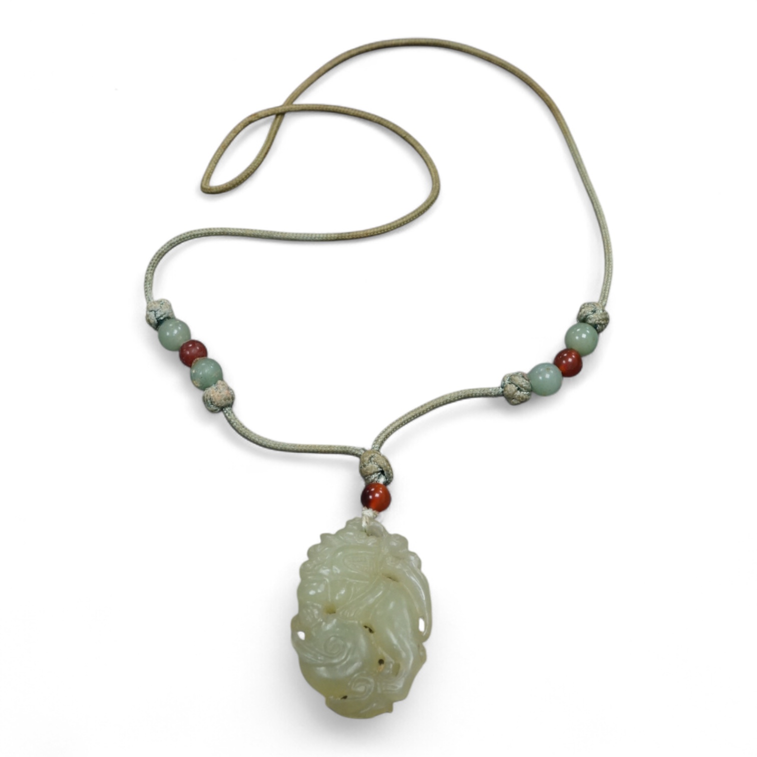 A Chinese carved bowenite jade pendant, on knotted beaded cord, pendant 6cm long.